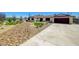 Single-story home boasts mature landscaping, well kept lawn, and a lengthy concrete driveway at 3917 Leon Ave, Las Vegas, NV 89130
