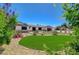 Well-manicured front yard featuring colorful flowers, shrubs, a green lawn, and desert landscaping at 3917 Leon Ave, Las Vegas, NV 89130