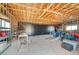 Unfinished garage featuring an open wood beam ceiling, concrete floors and a wall of storage cabinets at 3917 Leon Ave, Las Vegas, NV 89130