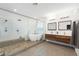 Bright bathroom featuring double sinks, modern wood cabinets, a soaking tub, and glass-enclosed shower at 3934 Sangre De Cristo Ave, Las Vegas, NV 89118