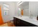 Charming bathroom featuring dual sinks, warm tiled floors, a window view, and a shower with an orange curtain at 3934 Sangre De Cristo Ave, Las Vegas, NV 89118