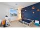 bedroom with a blue accent wall with planets, neutral carpet, window view, and creative, playful decor at 3934 Sangre De Cristo Ave, Las Vegas, NV 89118