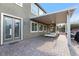 Covered outdoor patio with brick flooring, comfortable seating, and access to the house through sliding glass doors at 3934 Sangre De Cristo Ave, Las Vegas, NV 89118