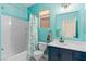 Bathroom in blue with a shower and bathtub combo, and vanity with a sink and dark fixtures at 4212 Helens Pouroff Ave, North Las Vegas, NV 89085