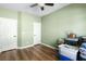 Spacious bedroom featuring modern wood floors, neutral paint, and a ceiling fan with a light fixture at 4212 Helens Pouroff Ave, North Las Vegas, NV 89085