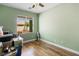 This bedroom has wood flooring, a window looking out onto the street, and neutral paint at 4212 Helens Pouroff Ave, North Las Vegas, NV 89085