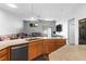 Open kitchen with tan countertops, stainless appliances, and adjacent living area at 4212 Helens Pouroff Ave, North Las Vegas, NV 89085