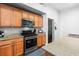 Kitchen with tan countertops, stainless steel appliances, wood cabinets, and hardware at 4212 Helens Pouroff Ave, North Las Vegas, NV 89085