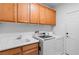 Functional laundry room featuring a utility sink, ample cabinetry, and modern washer and dryer at 4212 Helens Pouroff Ave, North Las Vegas, NV 89085