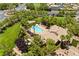 Aerial view showcases community pool with palm trees, green lawns and surrounding neighborhood at 4212 Helens Pouroff Ave, North Las Vegas, NV 89085