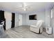 Living room featuring gray walls, gray wood flooring, large flat screen, and natural lighting at 4232 Park Ct, Las Vegas, NV 89110