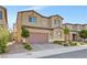 Two-story house with a two-car garage, small trees, and desert landscaping at 4641 Therapeutic St, North Las Vegas, NV 89031