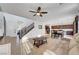 Open living room with tile floors, ceiling fan, staircase, and neutral decor at 4641 Therapeutic St, North Las Vegas, NV 89031