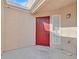 Enclosed porch with a red front door, stucco wall, and natural light, creating a welcoming entry at 4708 Cohiba Way, North Las Vegas, NV 89031