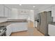 Open kitchen with stainless steel appliances, white cabinetry, and seamless connection to the living area at 4708 Cohiba Way, North Las Vegas, NV 89031