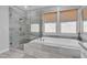 This bathroom offers a glass shower and tub combo, with neutral-toned tiles and plenty of natural light at 5927 Villa Loma St, Las Vegas, NV 89148