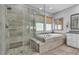 This luxurious bathroom boasts a glass-enclosed shower, soaking tub, and elegant neutral-toned finishes at 5927 Villa Loma St, Las Vegas, NV 89148