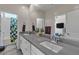 Bathroom featuring double sinks with white cabinets and a large mirror with decorative flower accents at 5927 Villa Loma St, Las Vegas, NV 89148