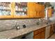 Kitchen with granite countertops, mosaic backsplash, and vintage-style cabinets at 624 N Bruce St, Las Vegas, NV 89101