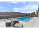 Luxurious backyard with a swimming pool, fire pit, and lounge seating perfect for outdoor relaxation at 6421 Winecup St, Las Vegas, NV 89149