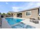 Beautiful backyard featuring a sparkling pool, jacuzzi, patio with outdoor kitchen, and lounge area at 6421 Winecup St, Las Vegas, NV 89149