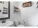A half-bath with a toilet, sink, and decorative shelving at 6421 Winecup St, Las Vegas, NV 89149