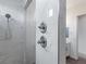 Detailed shot of the shower fixtures and marble tiling within the remodeled bathroom at 6421 Winecup St, Las Vegas, NV 89149