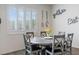 A casual dining area featuring a round wood table, six chairs, and a window with white shutters at 6421 Winecup St, Las Vegas, NV 89149