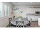 Eat-in kitchen featuring an oval dining table, wood-style floors, and bright natural lighting at 6421 Winecup St, Las Vegas, NV 89149
