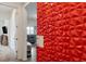 A hallway leading to a living room with a textured red decorative wall at 6421 Winecup St, Las Vegas, NV 89149
