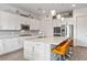 A modern kitchen featuring white cabinetry, stainless steel appliances, and a large island with bar seating at 6421 Winecup St, Las Vegas, NV 89149