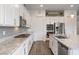 A well-lit kitchen with stainless steel appliances, white cabinets, granite countertops and wood-look flooring at 6421 Winecup St, Las Vegas, NV 89149