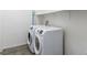 Functional laundry room featuring modern white front-load washer and dryer set and white shelving for convenient storage at 6421 Winecup St, Las Vegas, NV 89149