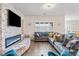A comfortable living room featuring a fireplace, large sectional sofa, and plenty of natural light at 6421 Winecup St, Las Vegas, NV 89149