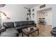 Living room with plush black sofa and warm wood-look flooring at 6421 Winecup St, Las Vegas, NV 89149