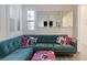 A cozy living room with a green sectional sofa, decorative pillows, and a stylish ottoman at 6421 Winecup St, Las Vegas, NV 89149