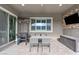 Inviting outdoor patio with a dining table, grill, heaters, mounted television and sliding glass doors for indoor-outdoor living at 6421 Winecup St, Las Vegas, NV 89149