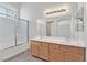 Bright bathroom with dual sink vanity, large mirror, and glass-enclosed shower at 6559 Tumbleweed Ridge Ln # 103, Henderson, NV 89011
