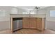 Eat-in kitchen boasting wood cabinetry, stainless steel appliances, and open access to the living space at 6559 Tumbleweed Ridge Ln # 103, Henderson, NV 89011