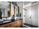 Modern bathroom features double sinks, wood cabinets, sleek mirrors, and a glass-enclosed shower at 658 Agate Bridge St, Las Vegas, NV 89138