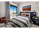 Comfortable bedroom featuring a large window, stylish decor, and a cozy reading nook with comfortable, modern chair at 658 Agate Bridge St, Las Vegas, NV 89138
