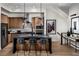 Modern kitchen with stainless steel appliances, dark countertops, and three bar stools at 658 Agate Bridge St, Las Vegas, NV 89138