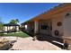 Inviting backyard with a gazebo, synthetic grass, stone patio, a mature palm, and covered patio with ceiling fans at 7250 Birkland Ct, Las Vegas, NV 89117