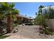 Serene backyard featuring a gazebo, gravel landscaping, and mature palm trees under a clear blue sky at 7250 Birkland Ct, Las Vegas, NV 89117