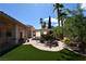 Lush backyard features a pond, mature landscaping, synthetic grass, and shade from the covered patio and mature trees at 7250 Birkland Ct, Las Vegas, NV 89117