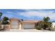 Three-car garage in a single-story home, boasting desert landscaping and beautiful architecture at 7250 Birkland Ct, Las Vegas, NV 89117