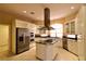 Gourmet kitchen featuring stainless appliances, custom cabinetry, granite counters, and center island at 7250 Birkland Ct, Las Vegas, NV 89117