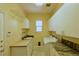 Laundry room with a sink, storage cabinets, granite countertops, and tile flooring at 7250 Birkland Ct, Las Vegas, NV 89117