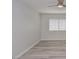 Bedroom features a ceiling fan, window with blinds, and light gray hardwood flooring at 7716 Bauble Ave, Las Vegas, NV 89128