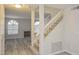 Inviting entryway with wood-look flooring, staircase, and sun-filled arched windows, providing a bright and welcoming space at 7716 Bauble Ave, Las Vegas, NV 89128